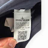 Étiquette d'authenticité avec code QR et logo Stone Island sur un pantalon de jogging noir Secondstore