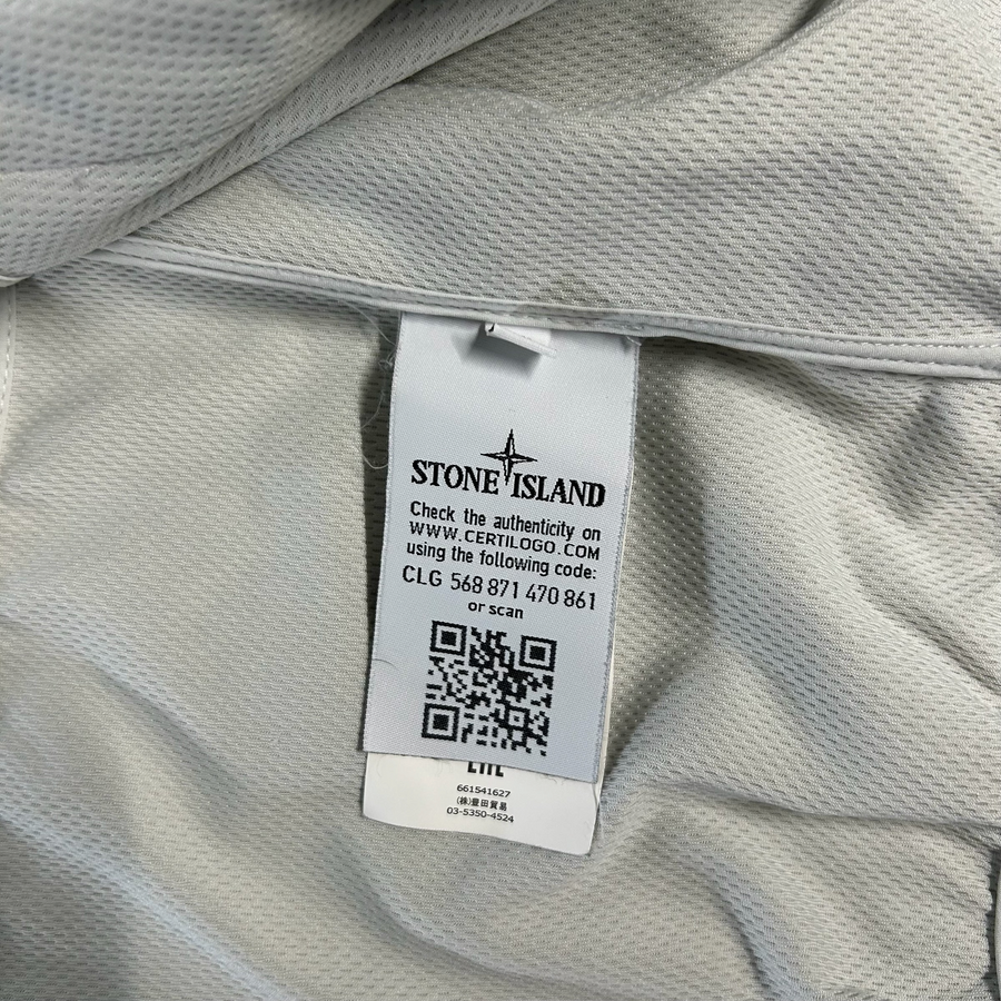 Étiquette d'authenticité intérieure Secondstore Stone Island avec code Certilogo et QR code sur tissu technique blanc