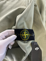 Secondstore Stone Island olive green crewneck sweatshirt featuring the iconic removable compass badge on the sleeve.