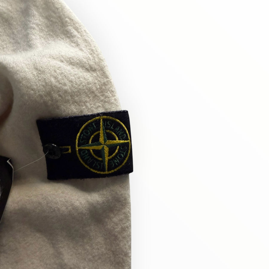 Badge boussole emblématique Stone Island sur un pull à col montant crème, disponible chez Secondstore