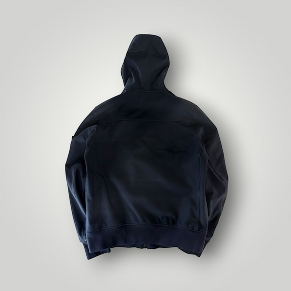 Back view of a black Secondstore Stone Island Soft Shell-R hooded jacket with ribbed hem and cuffs.