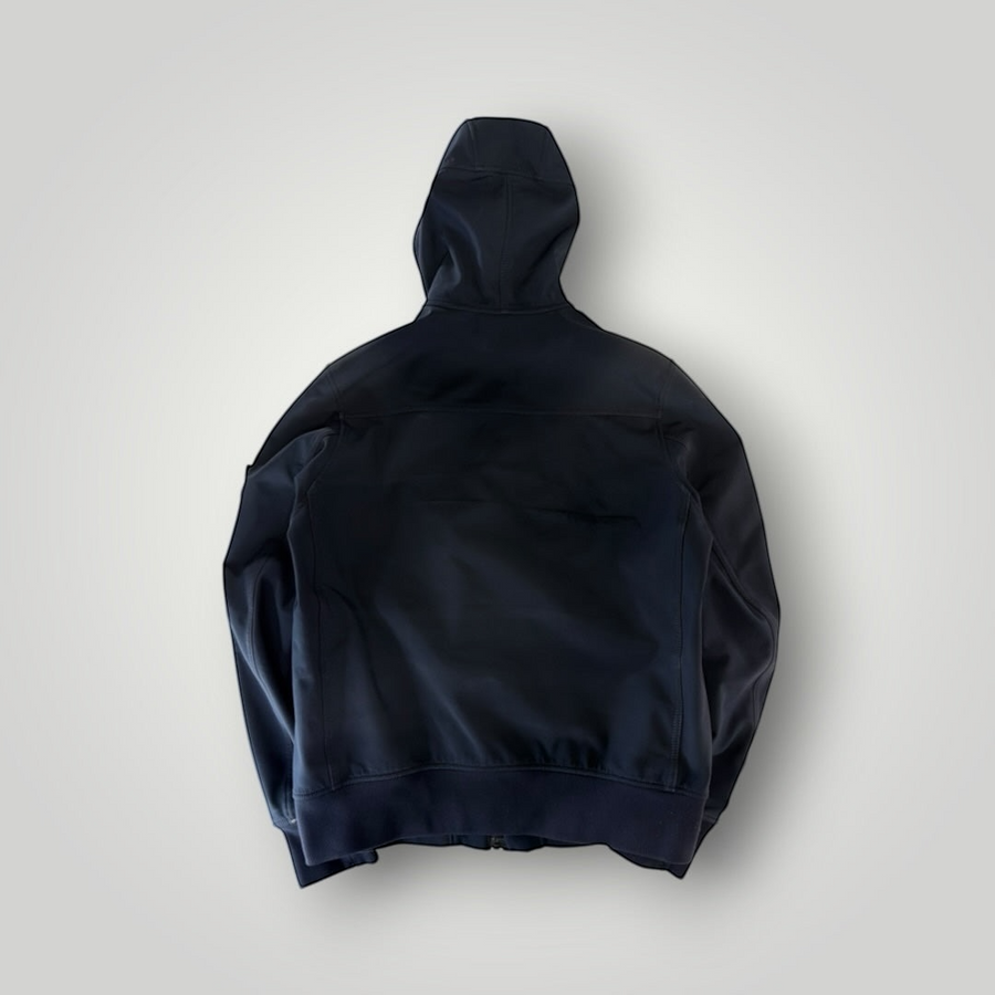 Back view of a black Secondstore Stone Island Soft Shell-R hooded jacket with ribbed hem and cuffs.