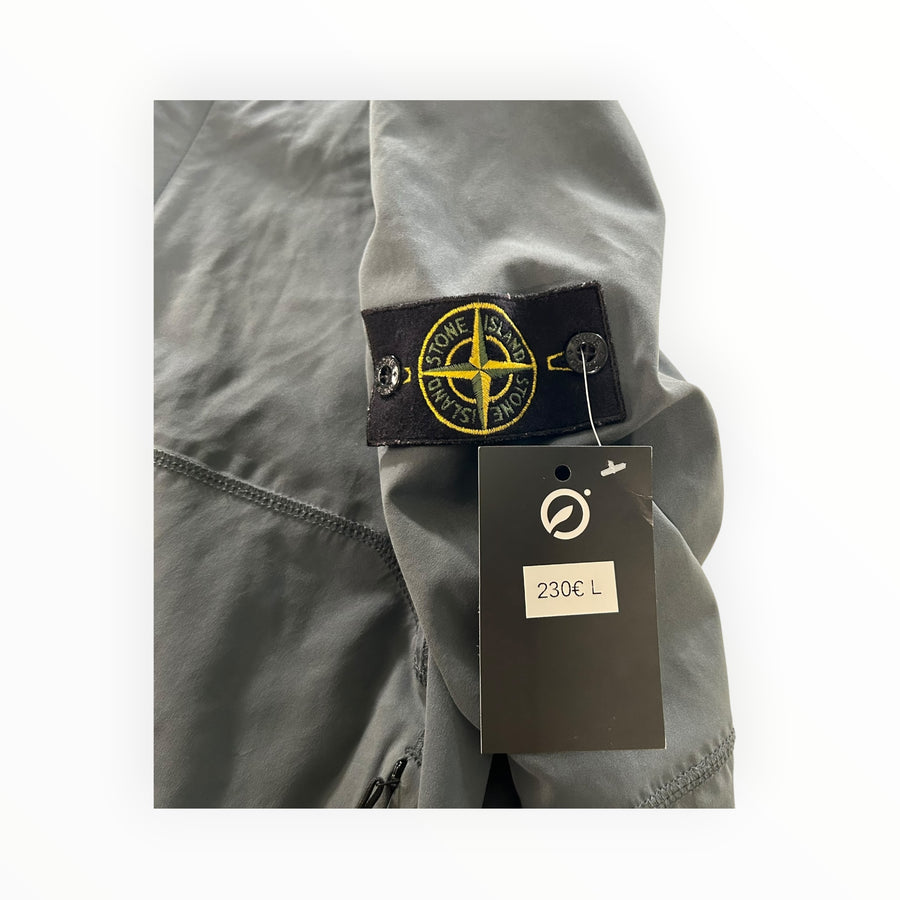 Secondstore Stone Island grey soft shell jacket sleeve with iconic compass badge and retail price tag attached