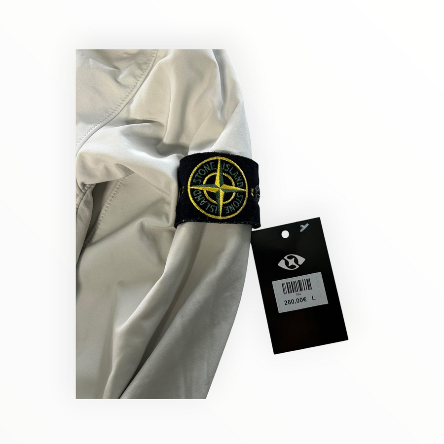 Secondstore Stone Island light grey soft shell jacket sleeve with iconic compass patch and original store price tag