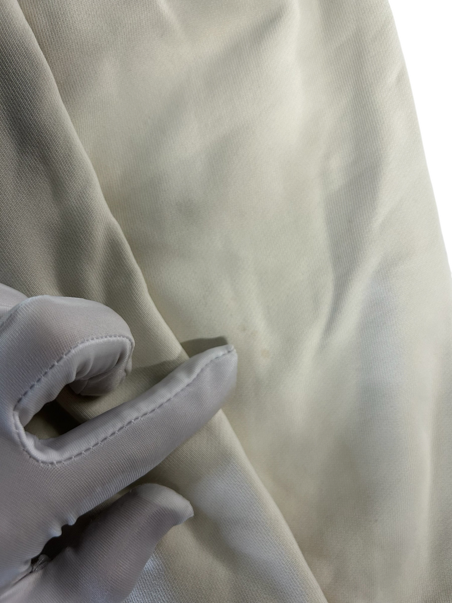 Gros plan sur le tissu en coton crème du sweat à capuche Secondstore Stone Island montrant de légères marques d'usure