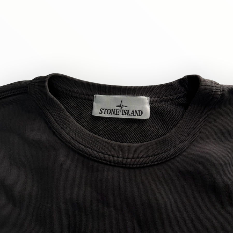 Gros plan sur le col rond d'un sweat-shirt Secondstore Stone Island en coton gris anthracite avec étiquette logo
