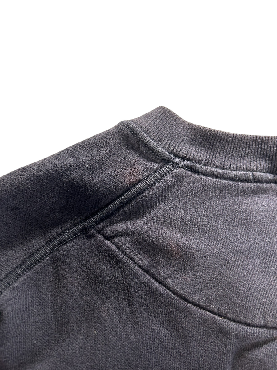 Gros plan sur l'épaule et le col côtelé d'un sweat-shirt Secondstore Stone Island en coton gris anthracite.
