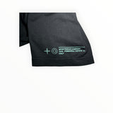 Détail de la manche d'un t-shirt Secondstore Stone Island en coton noir avec imprimé graphique vert menthe