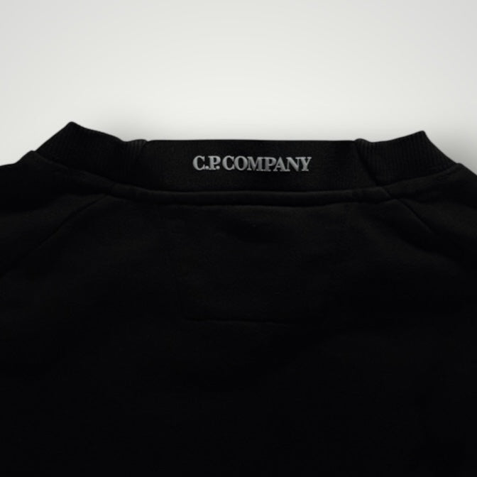Détail du col rond noir d'un sweat-shirt Secondstore C.P. COMPANY avec logo imprimé sur la nuque