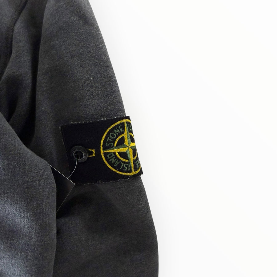 Gros plan sur le badge iconique Stone Island sur la manche d'un sweat-shirt gris Secondstore en coton délavé
