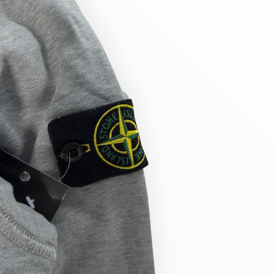Gros plan sur le badge Compass emblématique sur la manche d'un sweat-shirt gris Secondstore Stone Island en coton