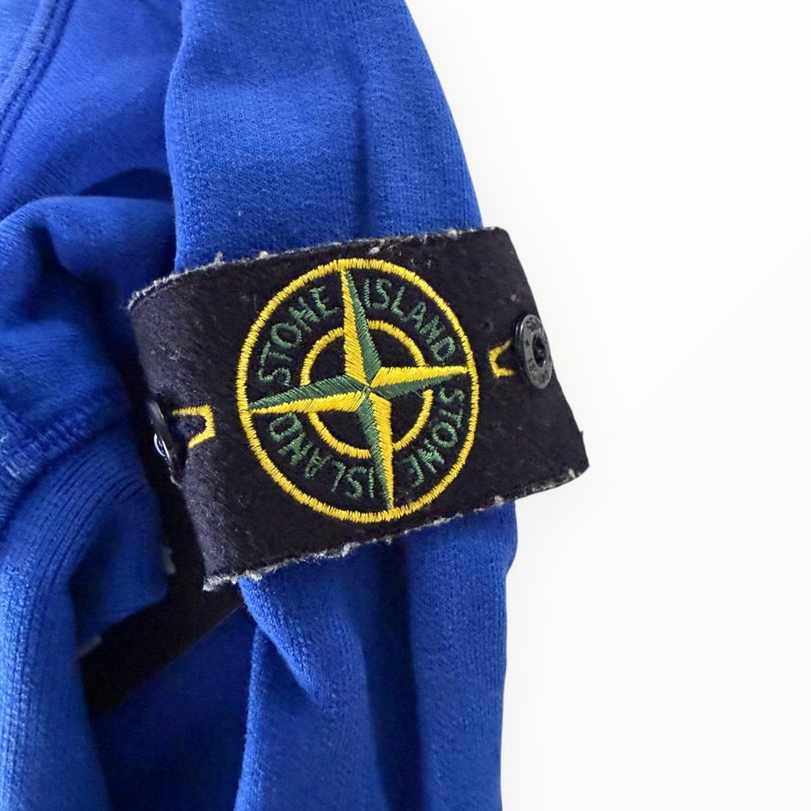 Badge boussole emblématique Stone Island sur la manche d'un sweat-shirt bleu électrique chez Secondstore