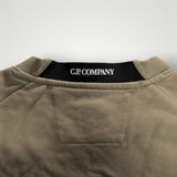 Détail du col rond Secondstore C.P. Company en coton beige avec bande intérieure noire et logo de la marque