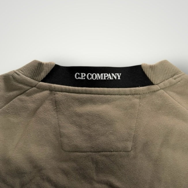 Détail du col rond Secondstore C.P. Company en coton beige avec bande intérieure noire et logo de la marque
