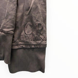 Détail du poignet d'un sweat-shirt marron Secondstore C.P. Company avec logo brodé ton sur ton sur le bord-côte