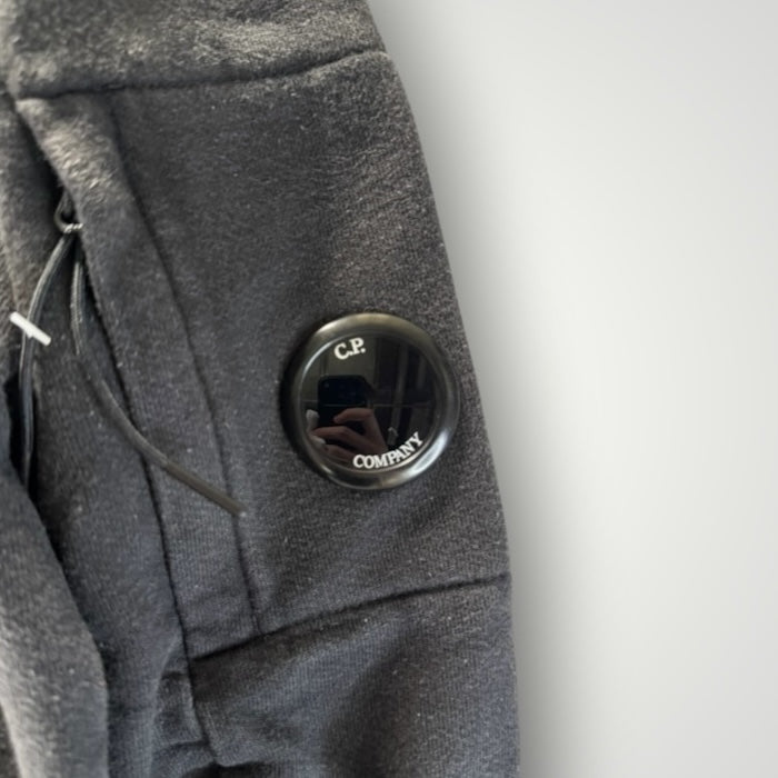 Détail de la manche noire en coton Secondstore avec poche zippée et lentille signature C.P. COMPANY