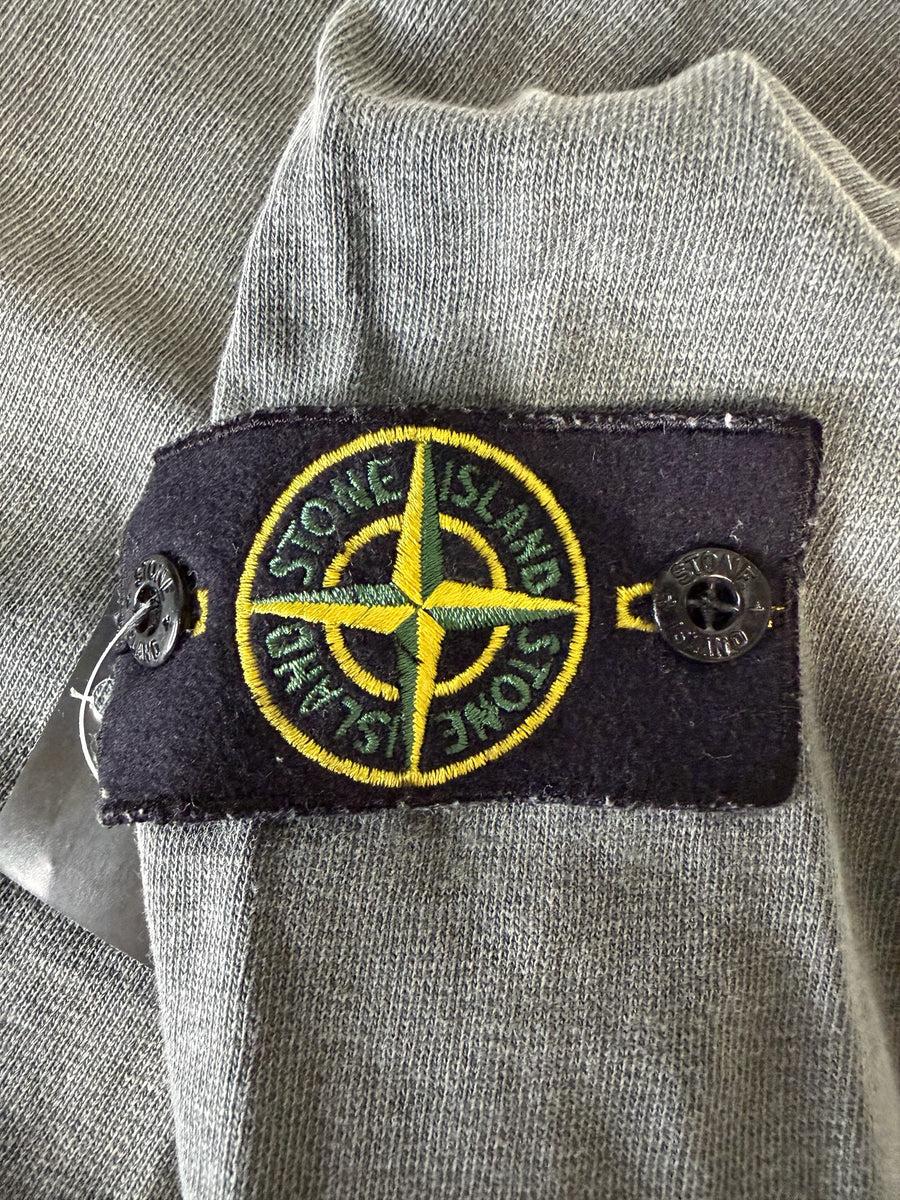 Badge emblématique Secondstore Stone Island sur la manche d'un sweat-shirt en coton gris à l'aspect délavé