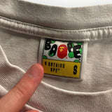 Étiquette de col Secondstore sur un t-shirt A Bathing Ape gris avec logo Ape Head coloré et taille S