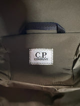 Étiquette de marque C.P. COMPANY cousue sur une veste kaki Secondstore, montrant le logo emblématique