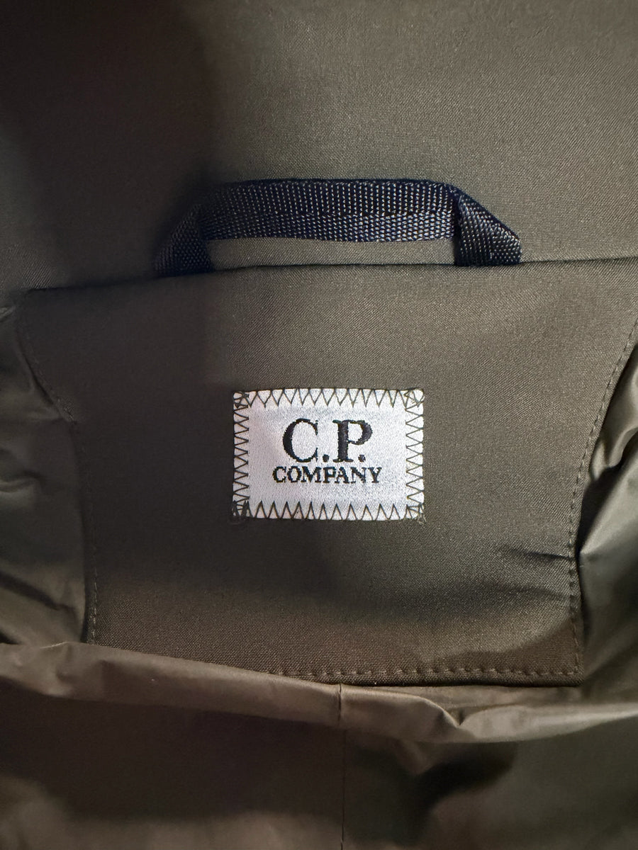 Étiquette de marque C.P. COMPANY cousue sur une veste kaki Secondstore, montrant le logo emblématique
