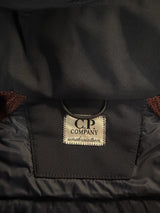 Gros plan sur l'étiquette intérieure Secondstore d'une veste C.P. Company noire avec détails matelassés