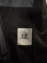 Étiquette intérieure de marque Secondstore sur une veste technique noire C.P. Company avec logo brodé