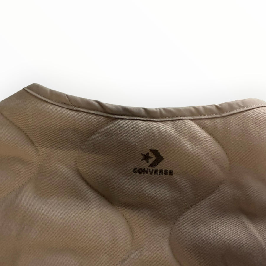Gros plan sur le col rond et le matelassage en losanges beige de la veste Secondstore Converse avec logo brodé
