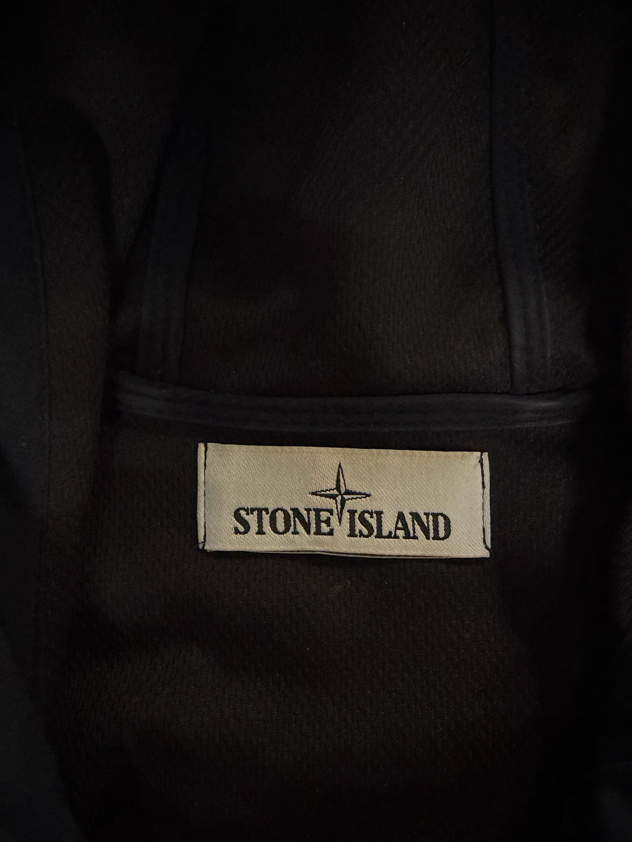 Étiquette intérieure de marque Stone Island sur une veste Secondstore bleu marine en tissu technique