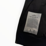 Étiquette intérieure Secondstore de veste Stone Island Light Soft Shell-R avec détails techniques sur fond noir