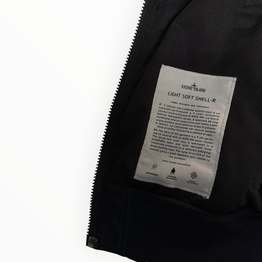 Étiquette intérieure Secondstore de veste Stone Island Light Soft Shell-R avec détails techniques sur fond noir