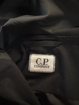 Étiquette intérieure de marque Secondstore sur une veste technique noire en tissu Pro-Tek de C.P. Company