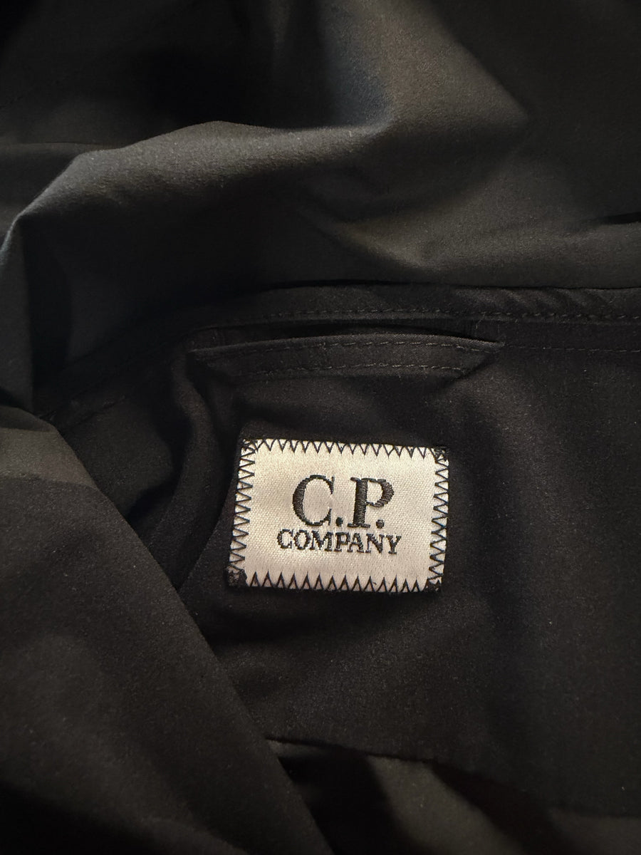 Étiquette intérieure de marque Secondstore sur une veste technique noire en tissu Pro-Tek de C.P. Company